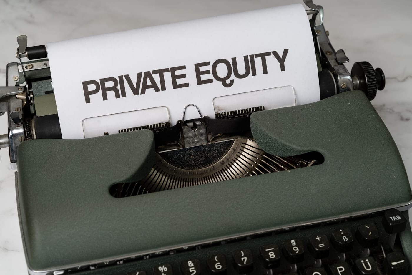 a close up of a typewriter with a paper that reads private equity