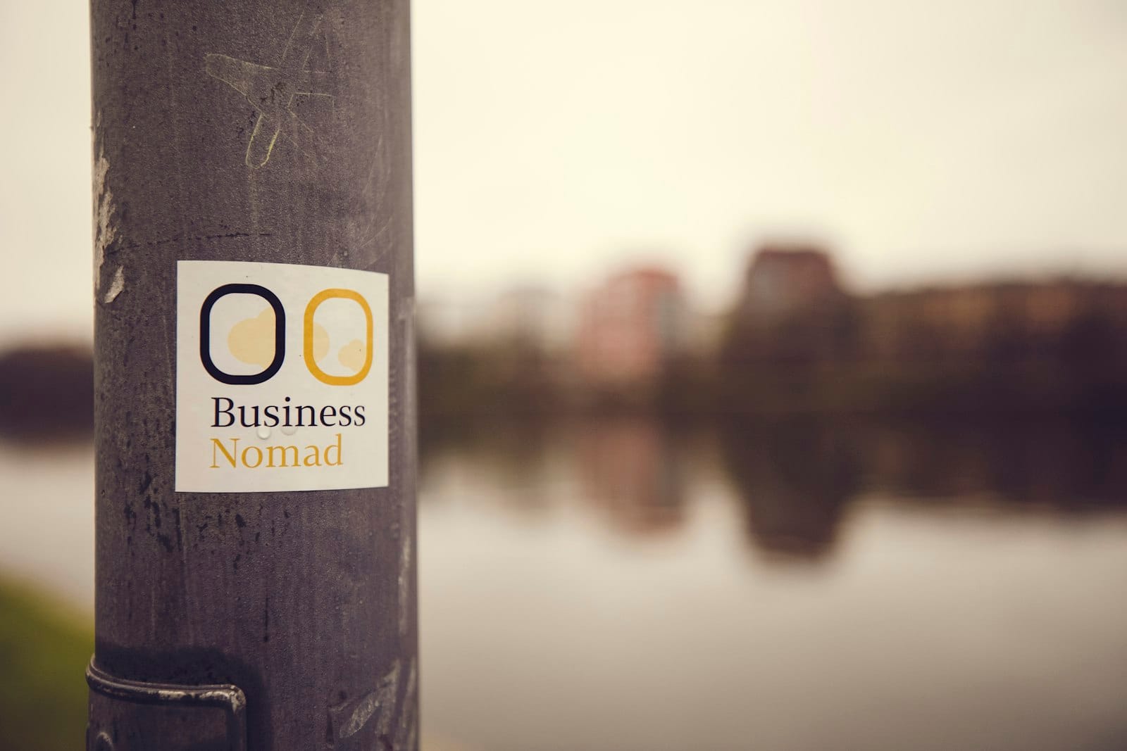 a sticker on a pole near a body of water