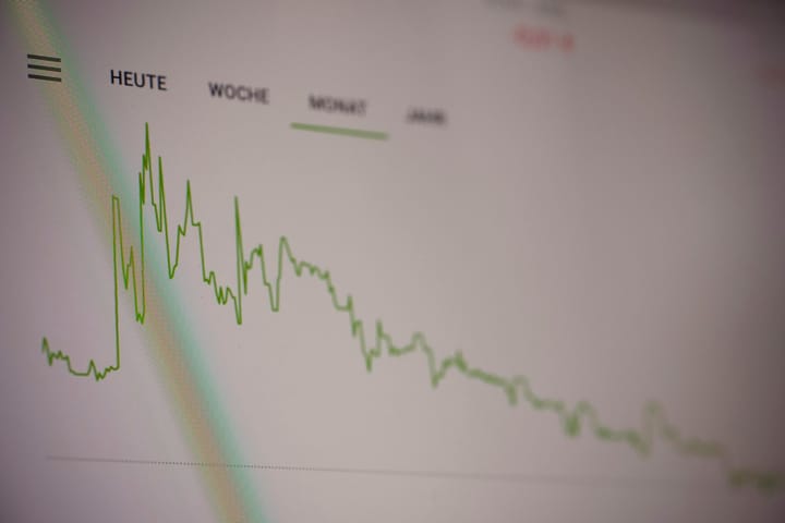 A green line graph showing stock market trends on a digital screen