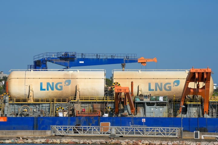 Two large lng tanks on a barge with cranes